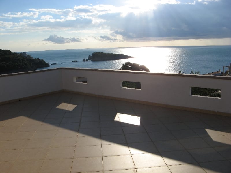 Przestronny taras z widokiem na morze i wyspę w Utjeha, Czarnogóra: wyłożony płytkami, z białymi barierkami.