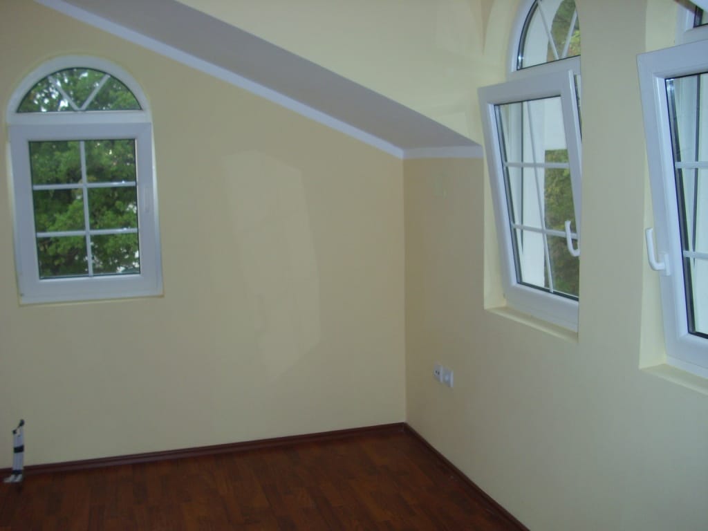 Bright bedroom with skylights and parquet flooring in a villa in Markovichi, Montenegro. Interior finished in pastel tones.