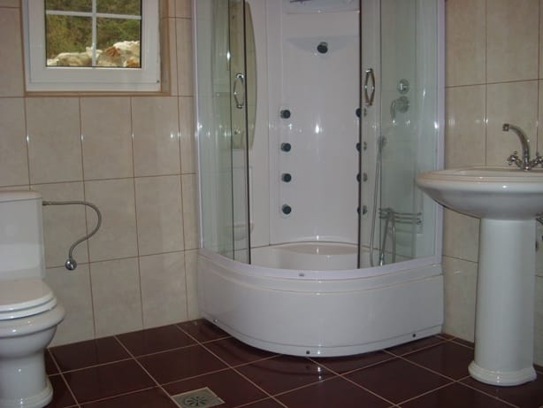 Bathroom with a shower cabin and light-colored tiles in a villa in Markovichi, Montenegro.