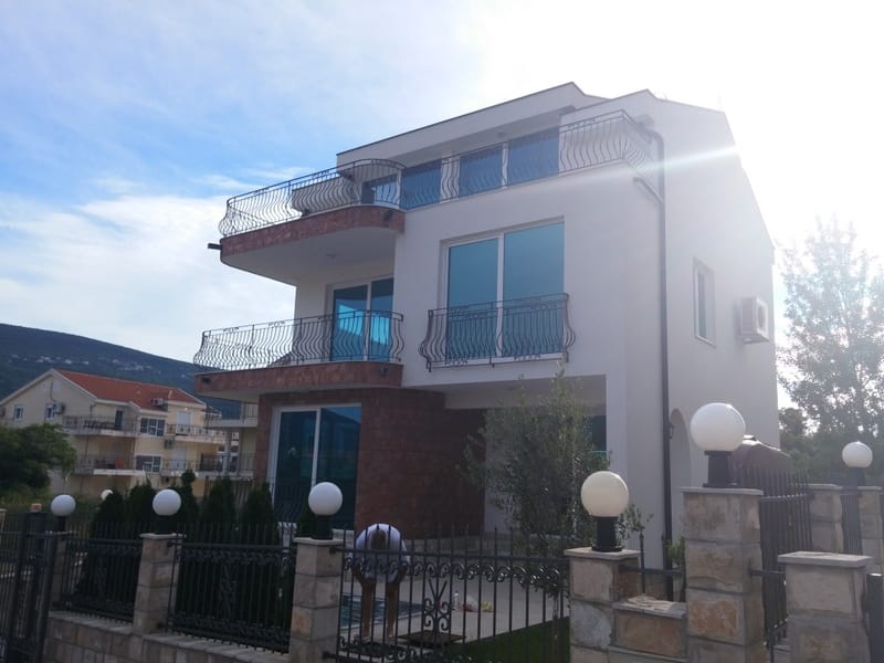 Three-story house in Đenovići, Montenegro: a modern villa with balconies, panoramic windows, and stone finishes.