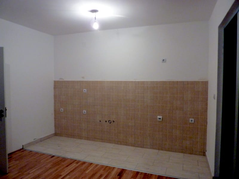 Küchenbereich in einem Apartment in Bečići, Montenegro: helle Fliesen, beigefarbener Fliesenspiegel und Anschlüsse für die Haustechnik.