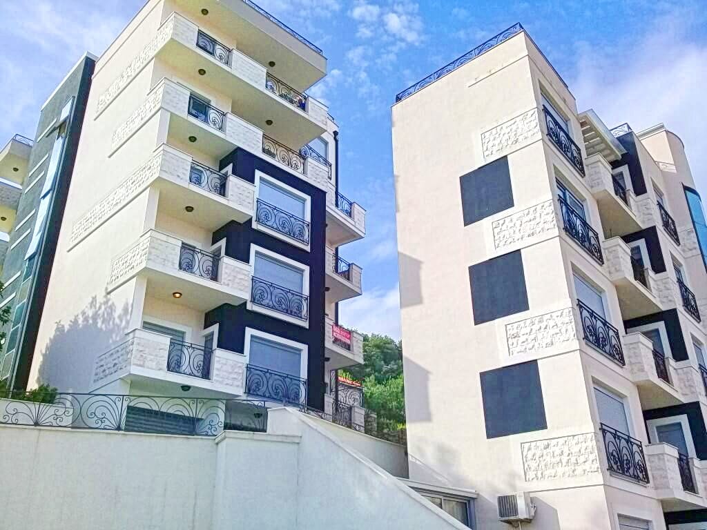 Modern residential complex with balconies and wrought-iron railings in Bečići, Montenegro: view of the building facade.