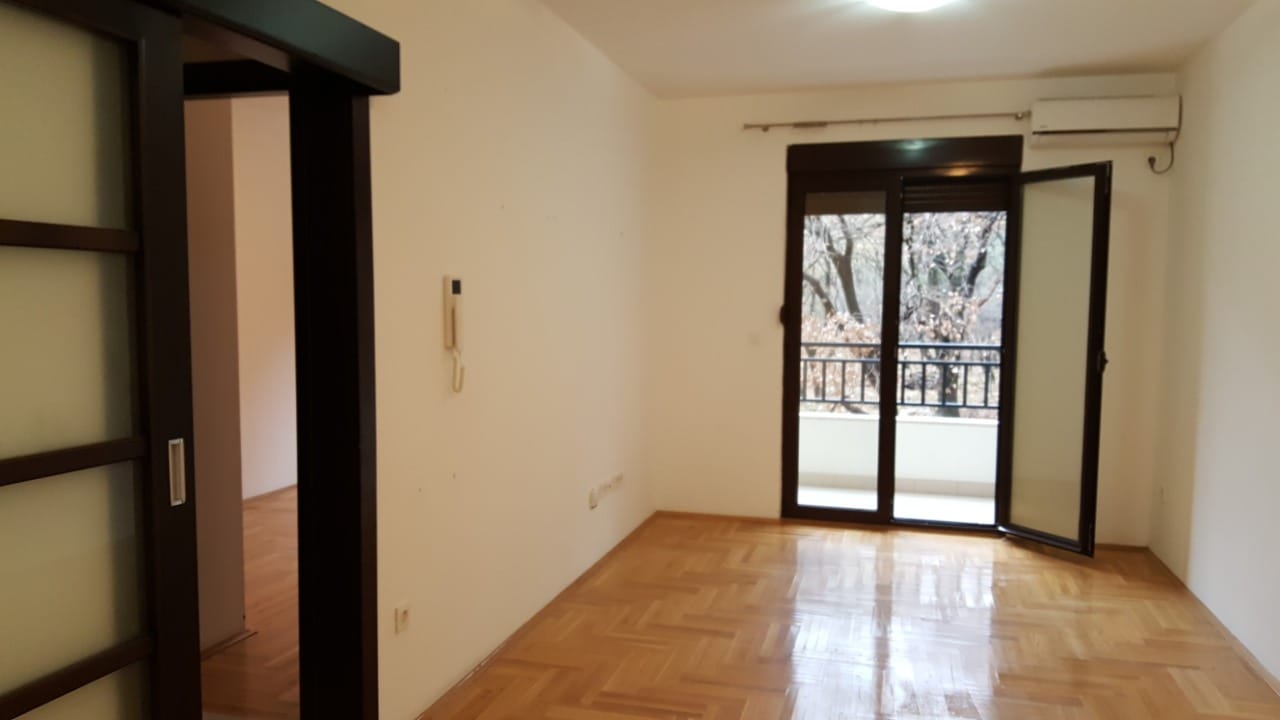 Karadağ, Budva'daki bir dairede parke zeminli, balkon çıkışlı ve klimalı aydınlık boş oda.