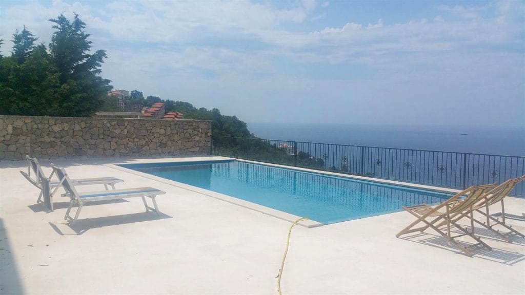 Открытый бассейн на вилле в Дробны песак, Черногория: терраса с шезлонгами и панорамным видом на Адриатическое море.