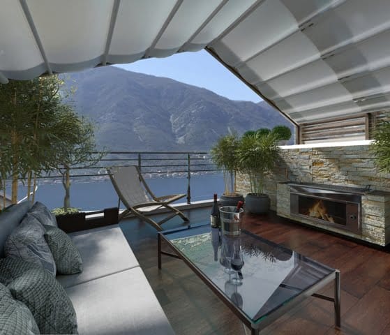 Terrasse der Wohnung in Dobrota, Montenegro: Meerblick, Berge, Außenkamin, weiche Möbel und Sonnenschutz.