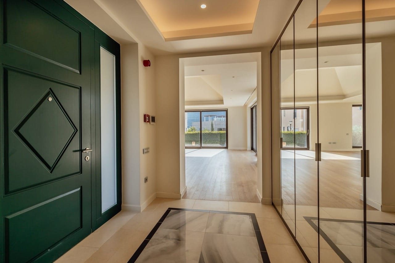 Villa hallway in Portonovi, Kumbor, Montenegro: green front door, mirrored wardrobe, and a view of the terrace.