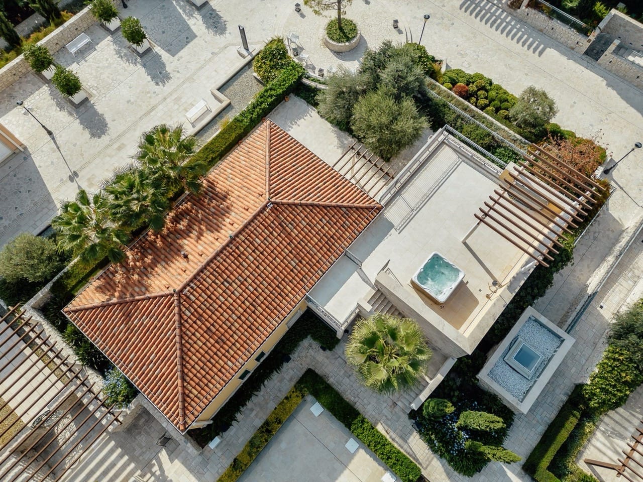 Top view of a villa in Portonovi, Kumbor, Montenegro: tiled roof, terrace with jacuzzi, and landscaped design.