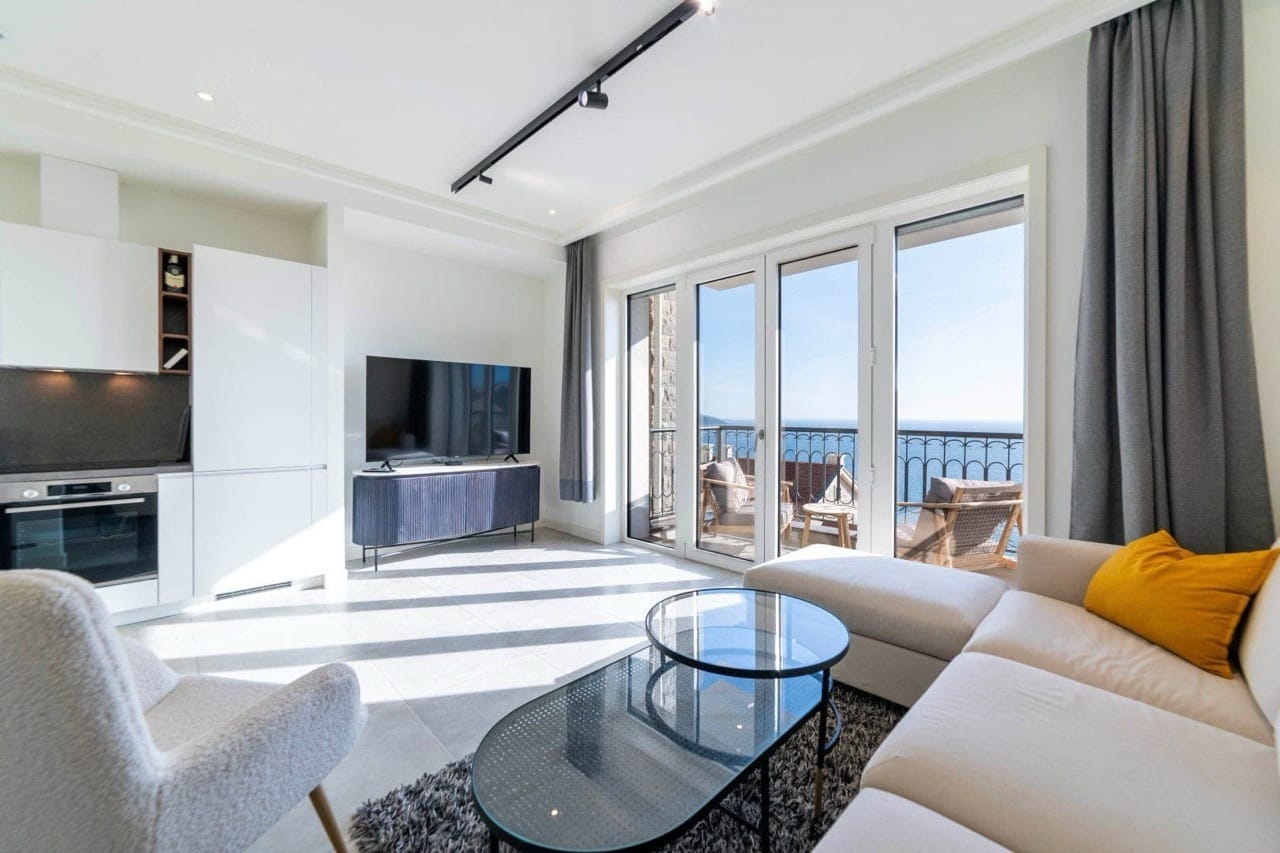 Modernes Wohnzimmer mit Küche in den Apartments von Luštica Bay, Radovići, Montenegro, mit Panoramablick auf das Meer und Terrasse.