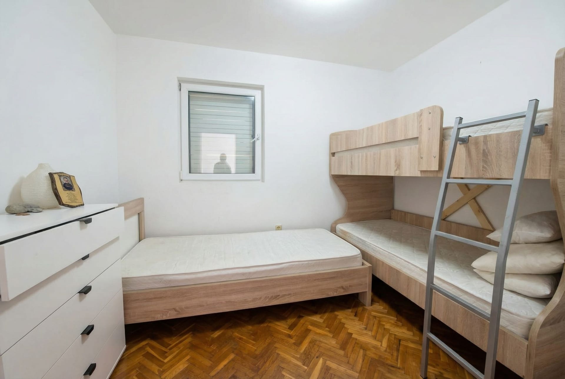 Children’s bedroom with a bunk bed and parquet flooring in an apartment in the Sveti Stefan resort, Montenegro.