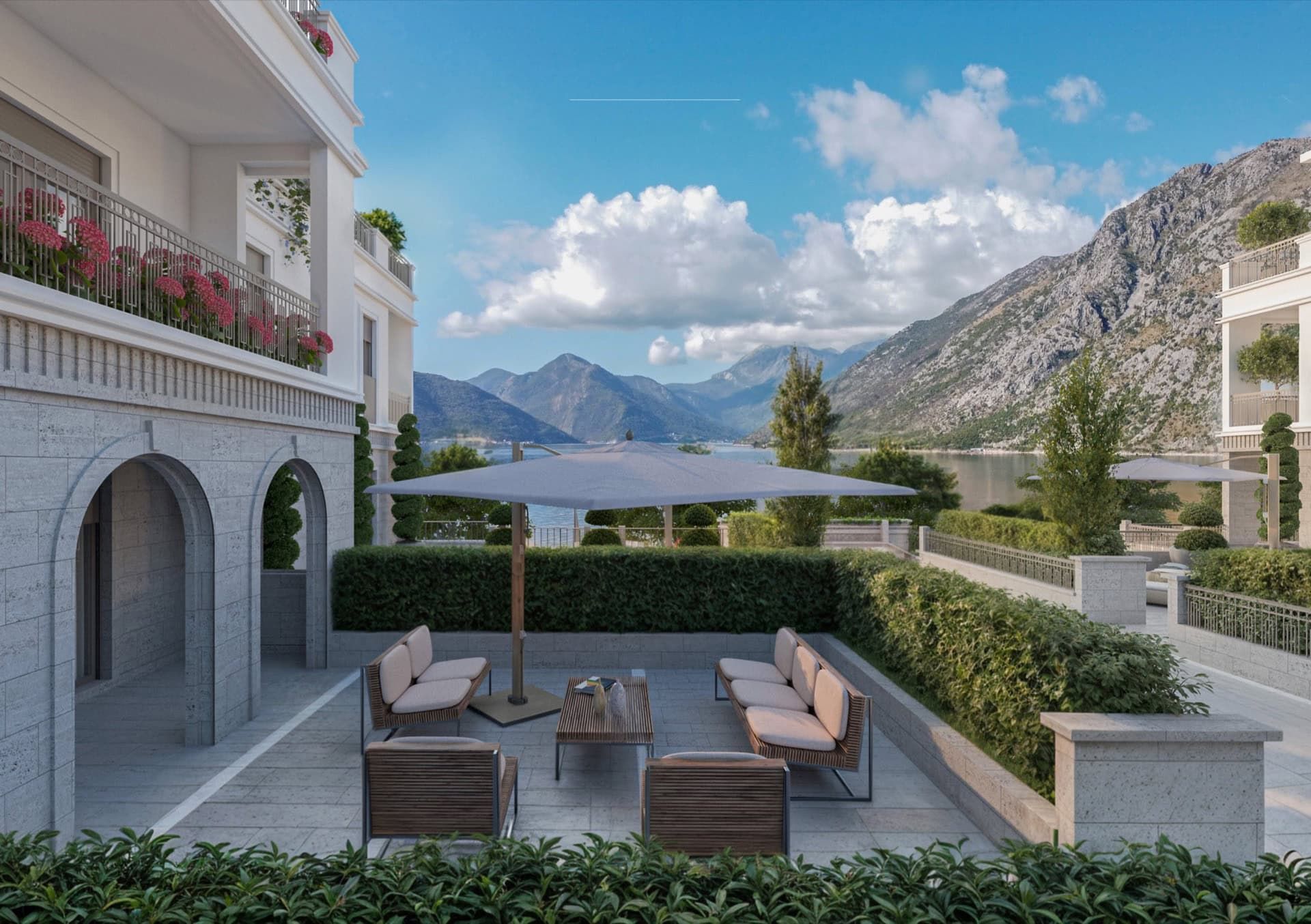 Terrasse avec mobilier de jardin dans un complexe résidentiel haut de gamme à Luštica, Monténégro, avec vue sur la baie de Kotor et les montagnes.