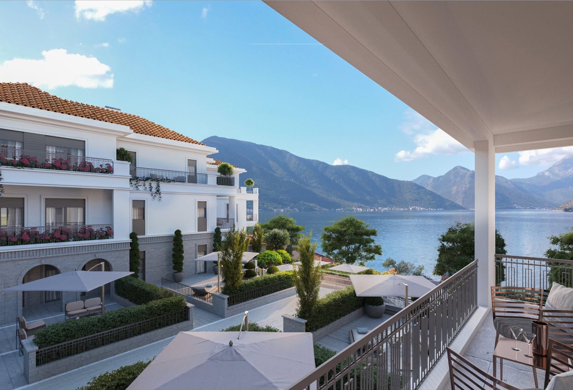 Vue depuis le balcon sur un complexe résidentiel à Ljuta, Monténégro : terrasses meublées, aménagement paysager et panorama sur la baie de Kotor.
