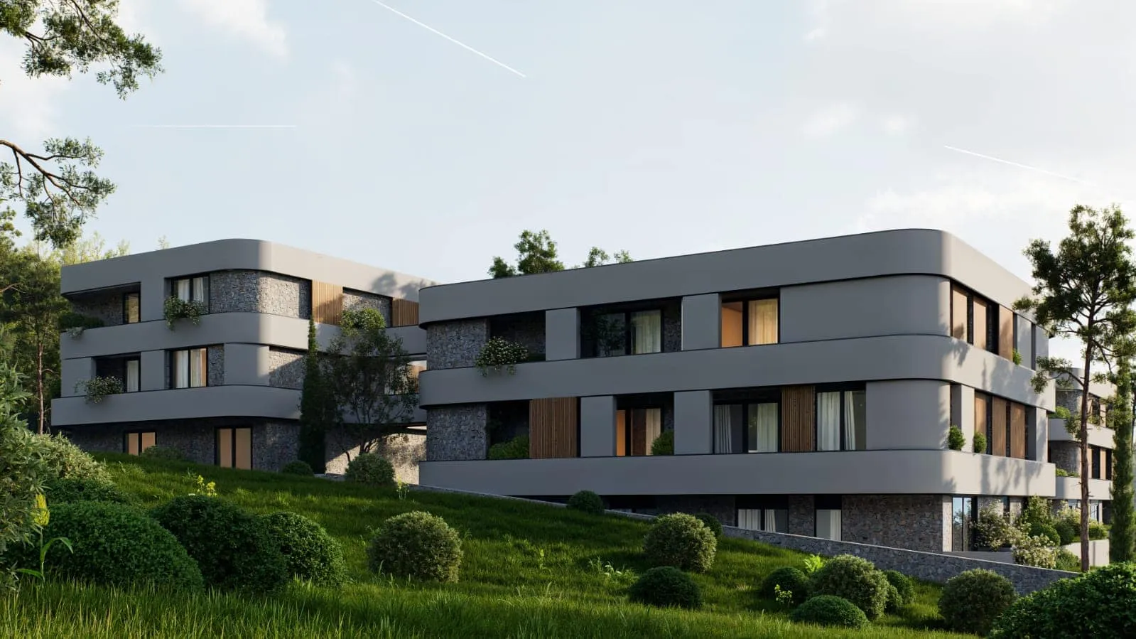 Moderne mehrstöckige Apartmentgebäude an einem Hang mit grünem Rasen