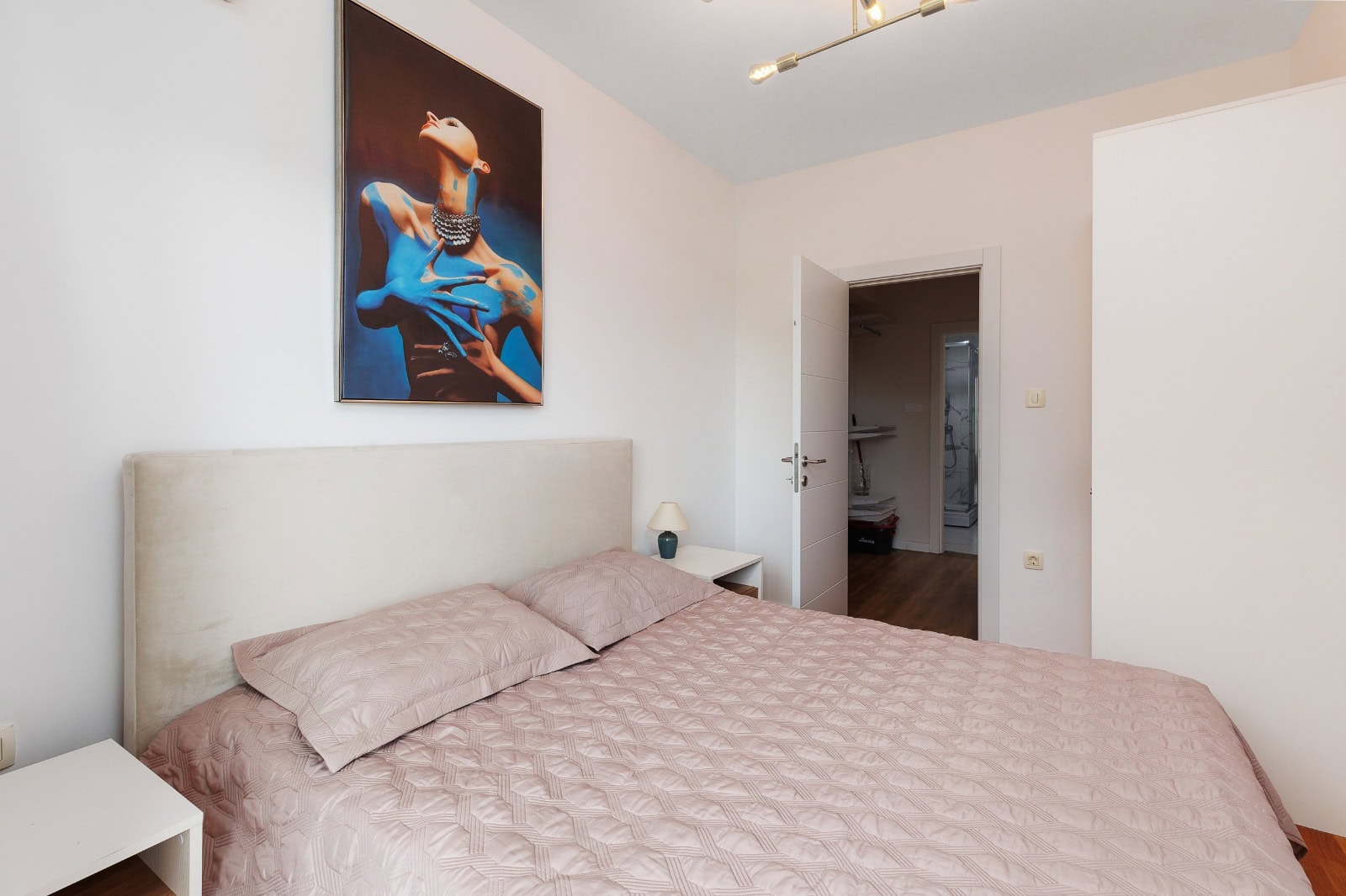 Modernes Schlafzimmer mit Doppelbett und Gemälde in einer Wohnung, Bečići, Montenegro