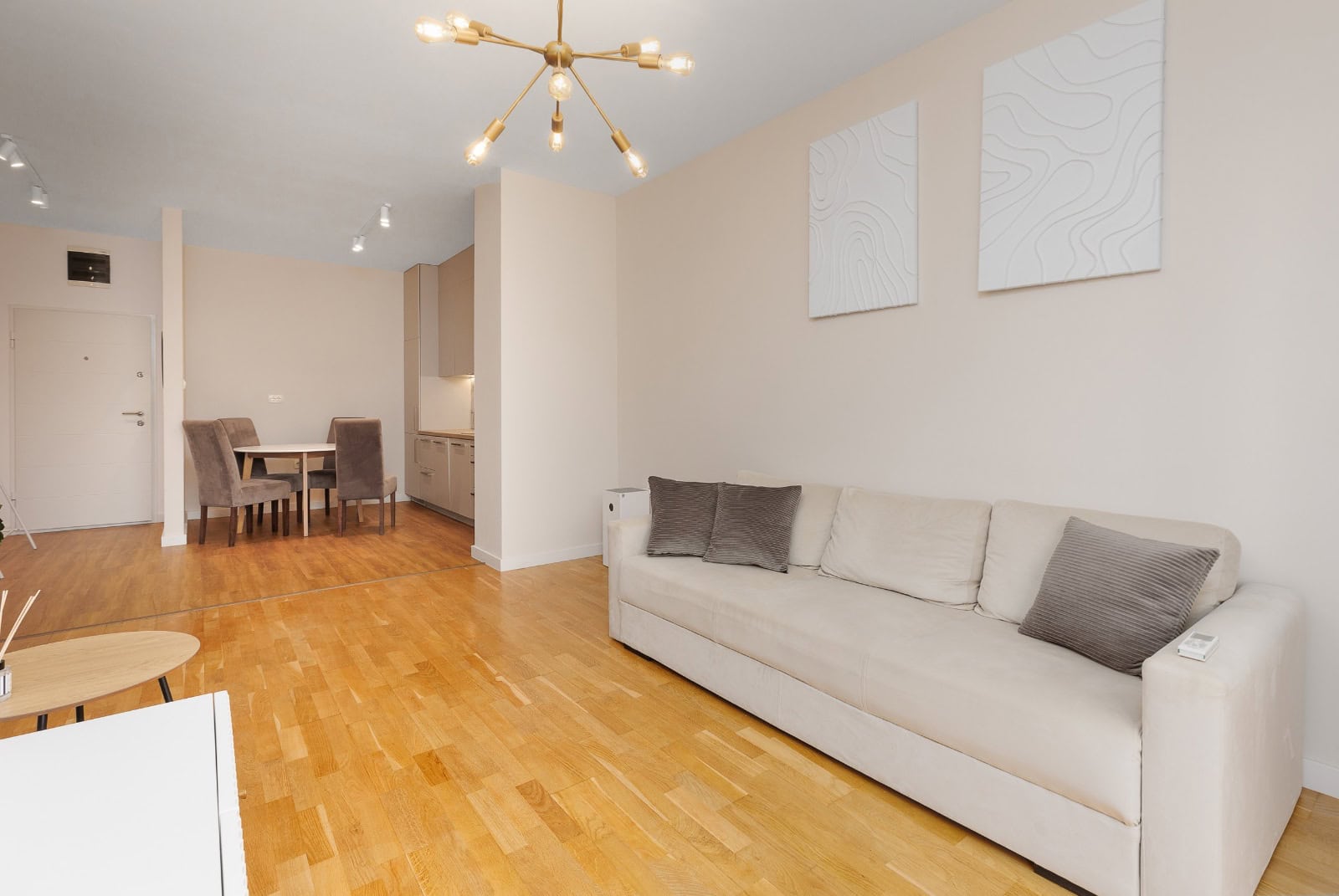 Helle Wohnzimmer mit beigem Sofa und Parkettboden in einer Wohnung in Bečići, Montenegro