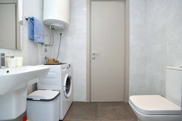 Modern bathroom with a shower and washing machine in an apartment in Bečići, Budva, Montenegro.