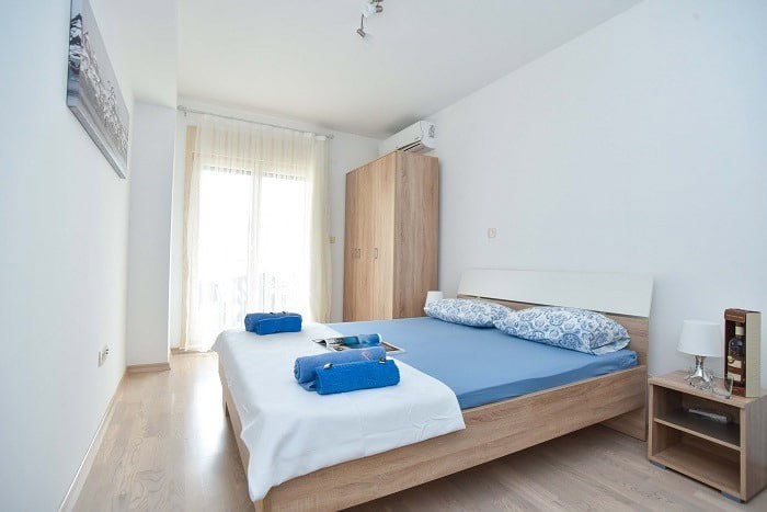 Bright bedroom with a double bed and wardrobe in an apartment in Bečići, Budva, Montenegro.