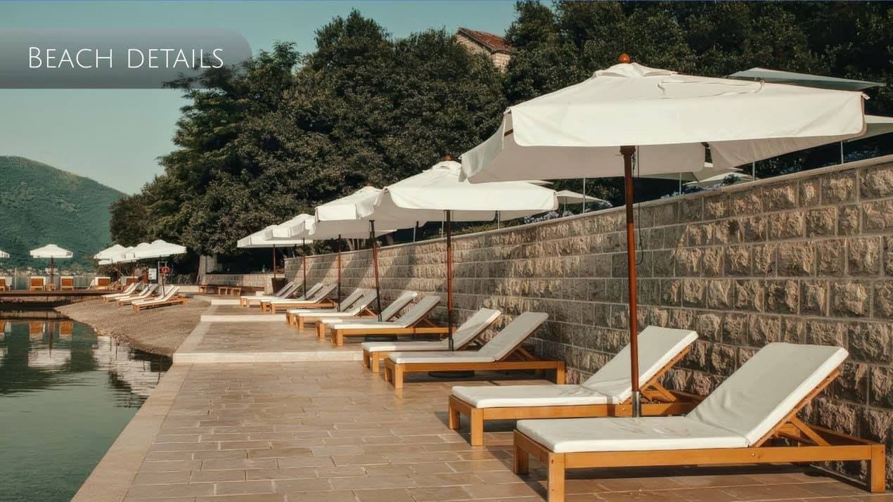Privatna plaža sa ležaljkama i suncobranima uz kameni zid u Orahovcu, Crna Gora: zona za odmor uz more.