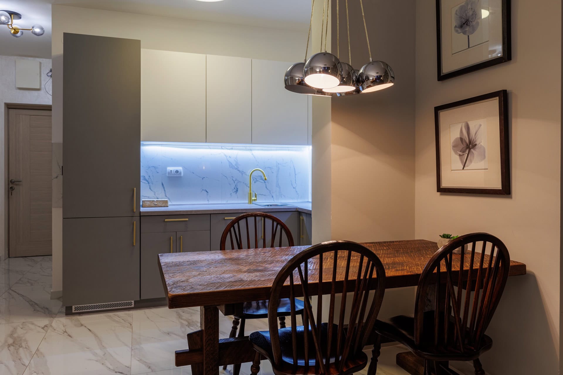 Moderne Küche in einer Wohnung in Bečići, Montenegro: Essbereich mit Holztisch und stilvolle Küchenzeile.