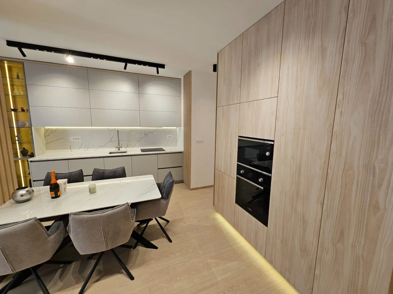 Moderne Wohnküche in einer Wohnung, Budva, Montenegro: helle Einbauküche, integrierte Geräte und Essbereich.