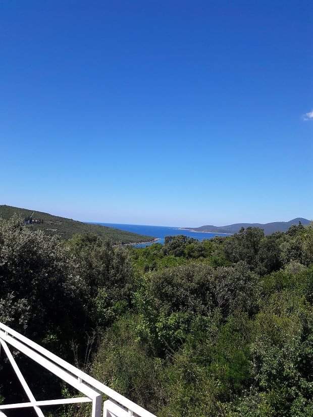 Blick vom Balkon der Villa in Bigovo, Montenegro: Panorama auf die Adria, grüne Hügel und dichten Wald.