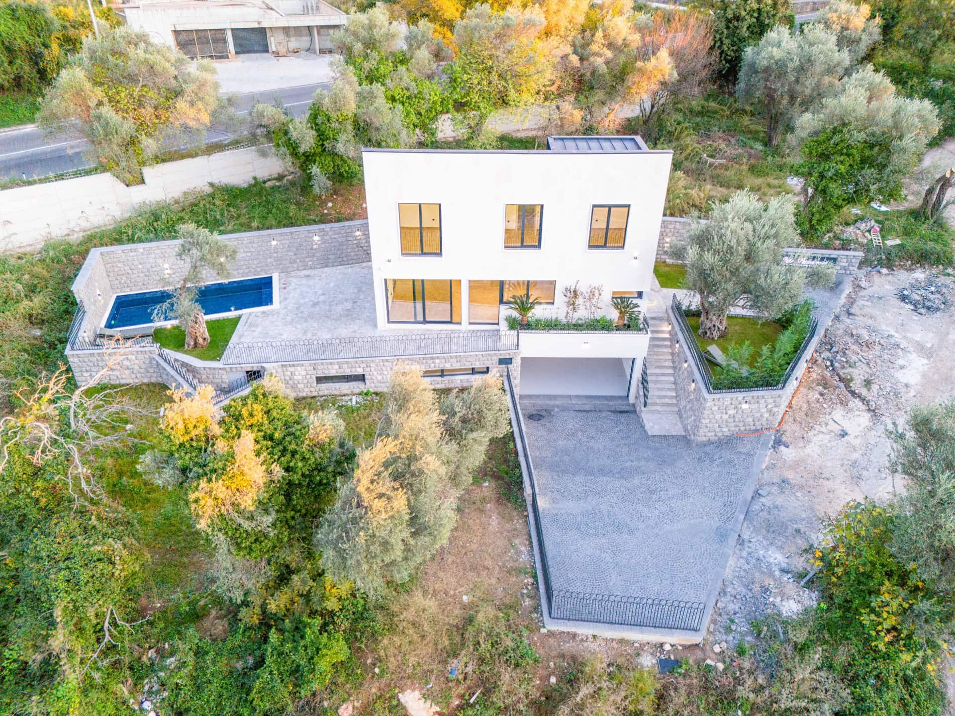 Moderne Villa in Kamenovo, Montenegro: Draufsicht auf das Haus mit Pool, Terrasse, Garten und Parkplatz.