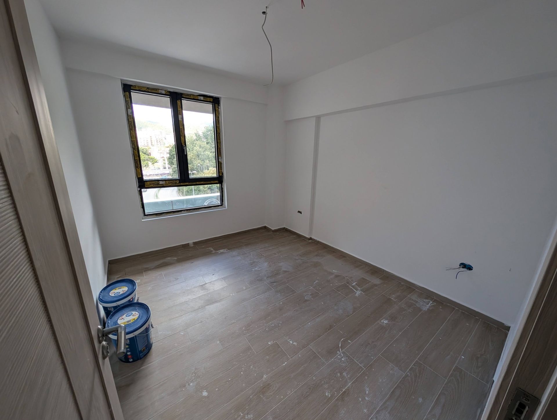 Chambre avec finition propre, murs blancs et carrelage imitation bois dans un appartement en construction, Rafailovići, Monténégro