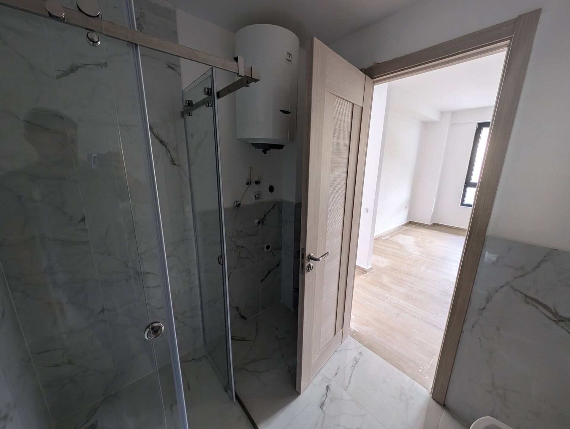 Salle de bain moderne avec douche et chauffe-eau dans un appartement en construction à Rafailovići, Monténégro