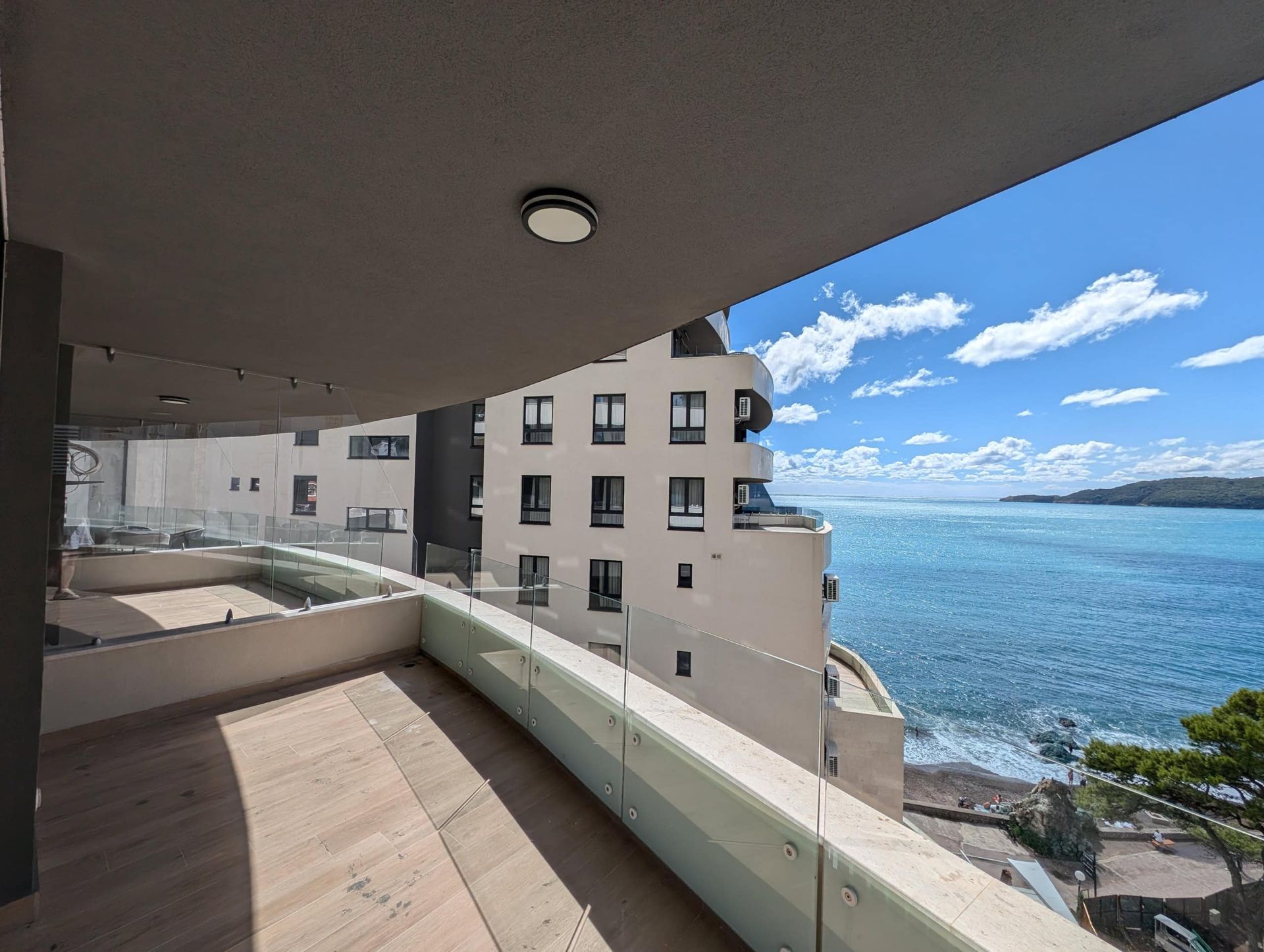 Balcon spacieux avec garde-corps en verre panoramique et vue sur la mer à Rafailovići, Monténégro