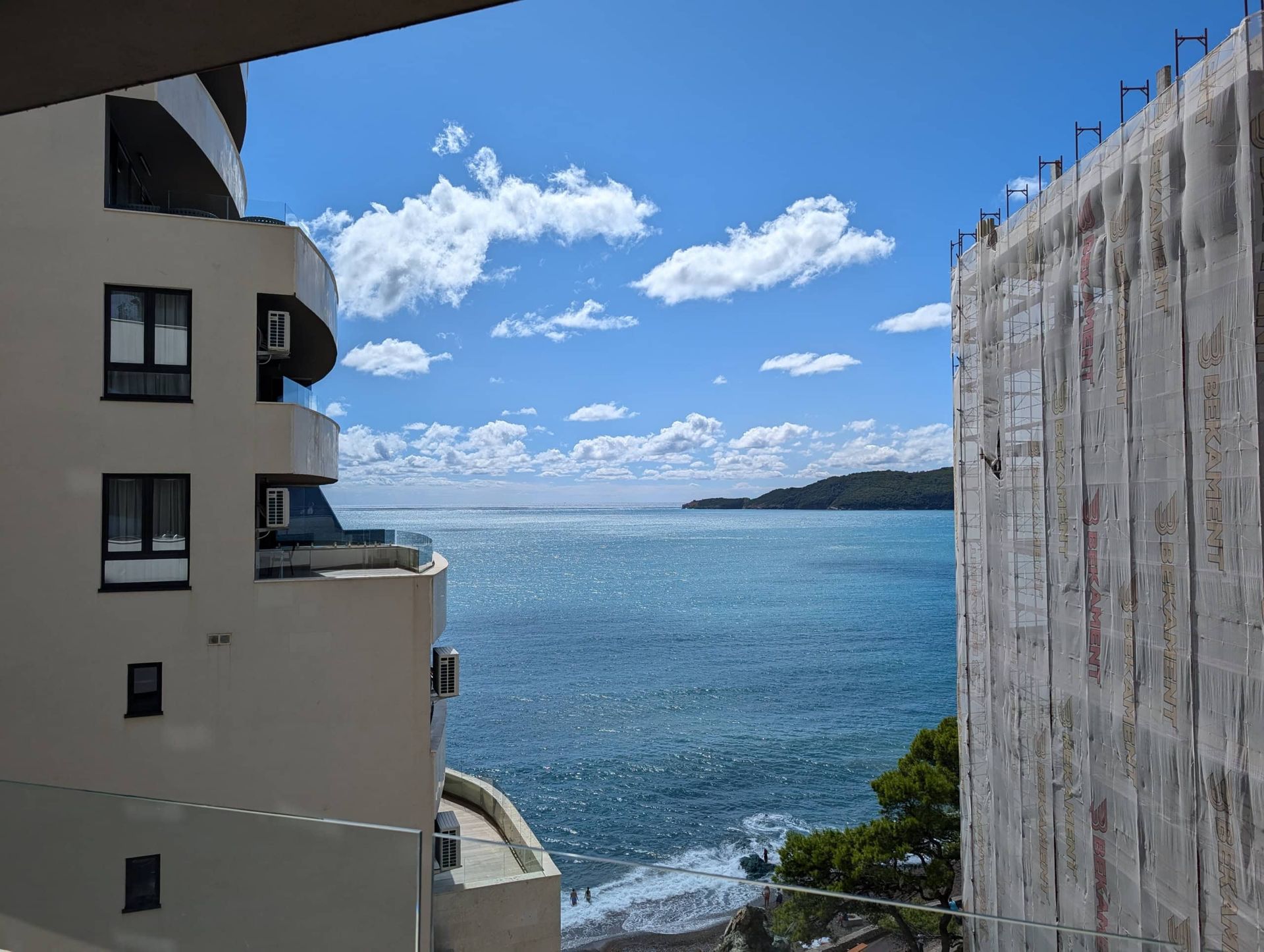 Vue sur la mer depuis le balcon de l'appartement à Rafailovići, Monténégro, entre les immeubles résidentiels