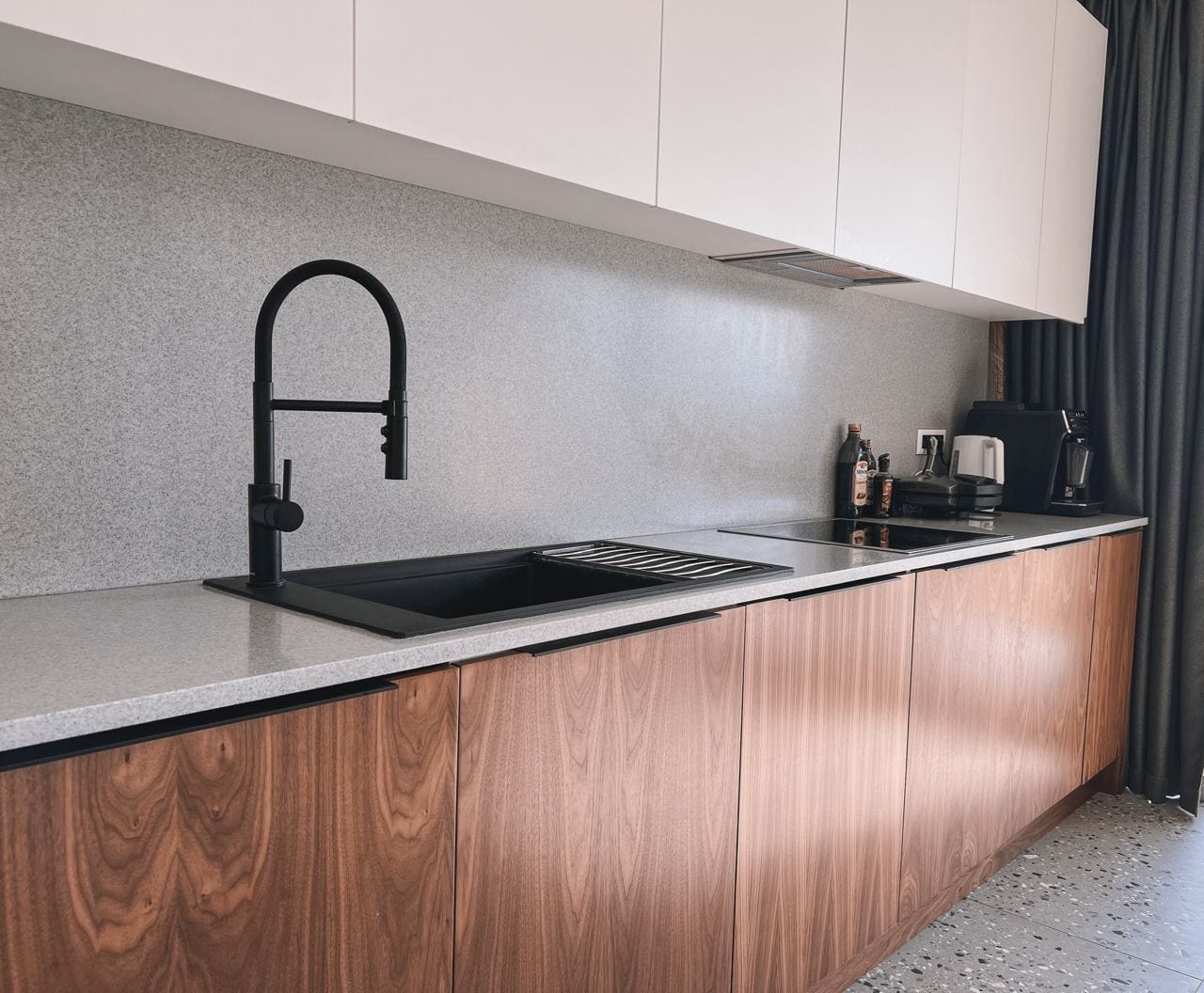 Moderne Küche mit Holzfronten und schwarzer Armatur in der Wohnanlage Kavac, Montenegro. Stilvolles Apartment-Interieur.