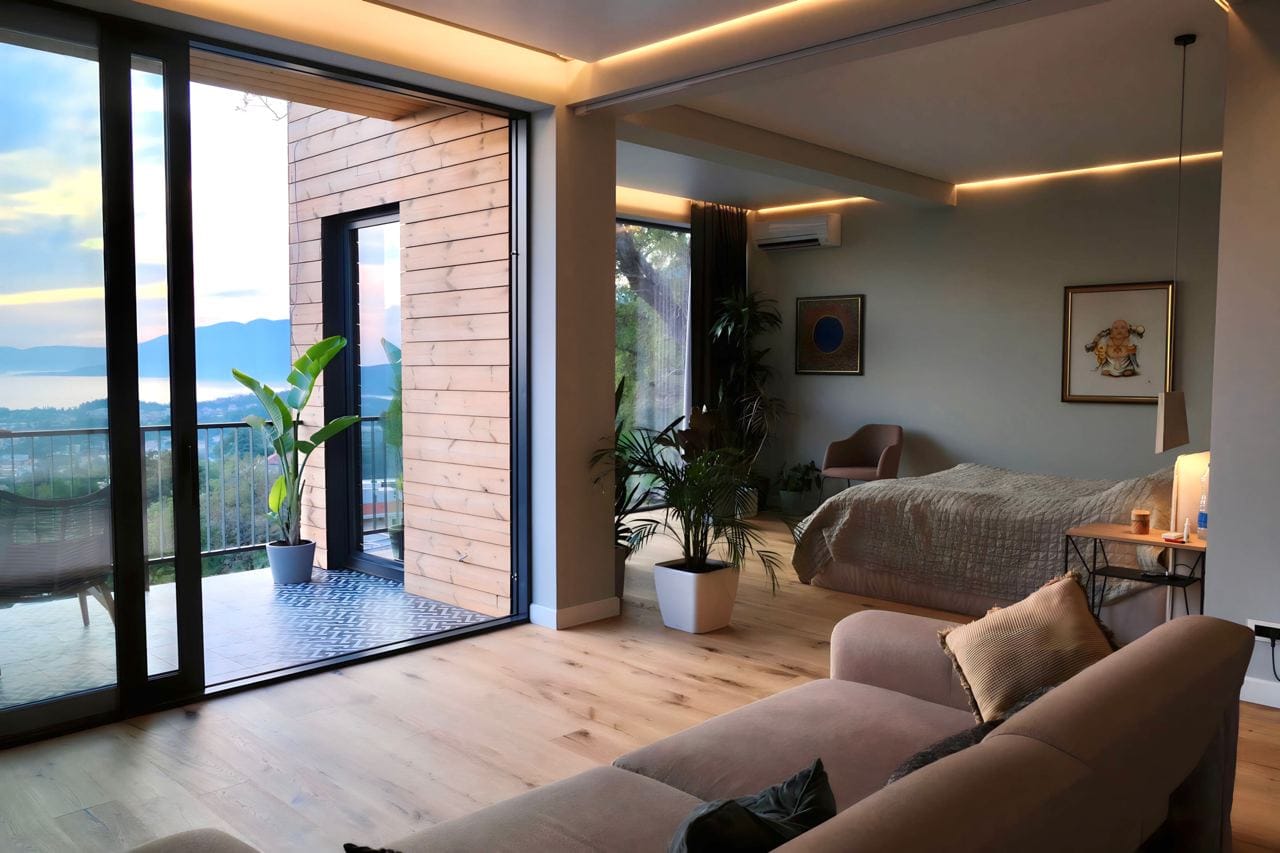 Modernes Wohnzimmer mit Panoramablick auf das Meer in der Wohnanlage Kavac, Montenegro: stilvolles Interieur, Terrasse und gemütliches Schlafzimmer.
