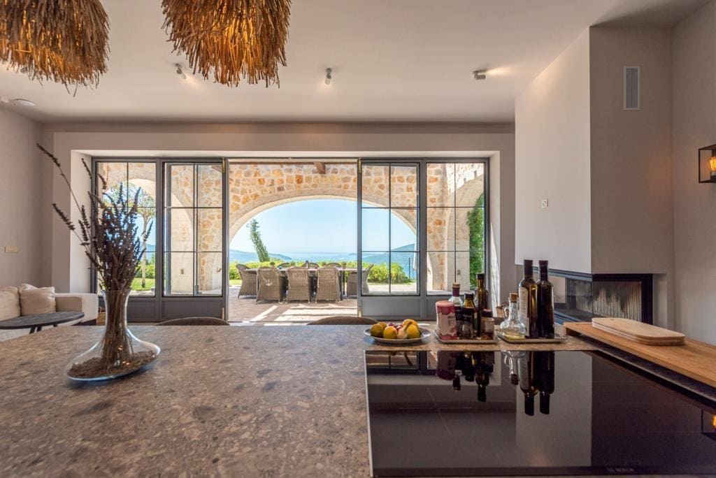 Cuisine moderne dans une villa à Herceg Novi, Monténégro, avec vue panoramique sur la mer et terrasse en pierre.