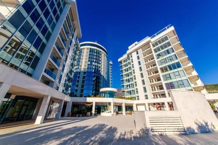 Moderner Wohnkomplex mit Panoramaverglasung in Budva, Montenegro: Blick auf die Fassade und das gepflegte Gelände.