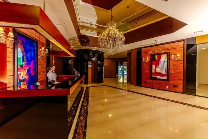 Luxuriöse Lobby mit Kristalllüster und Rezeption in einer modernen Wohnanlage in Budva, Montenegro.