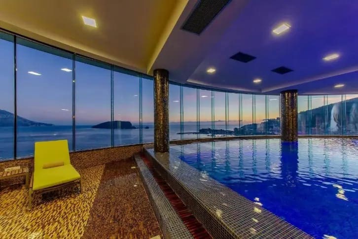 Überdachter Pool mit Panoramablick auf das Meer und die Insel in einer exklusiven Wohnanlage, Budva, Montenegro.