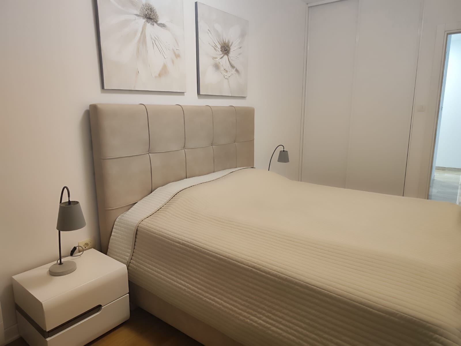 Gemütliches Schlafzimmer mit Doppelbett in einer Wohnung in Budva, Montenegro: moderne Möbel, helles Interieur und Dekor.