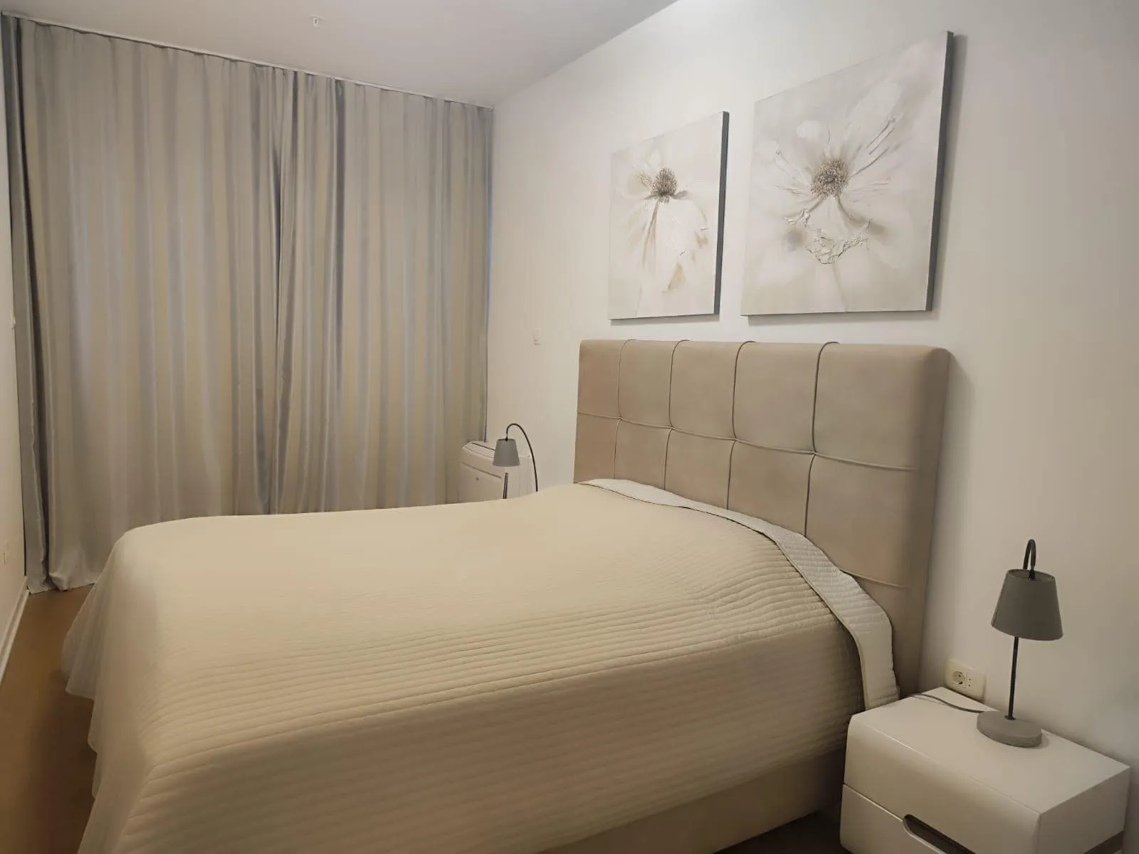 Cozy bedroom with a double bed in a modern apartment in Budva, Montenegro: bright interior and decor.