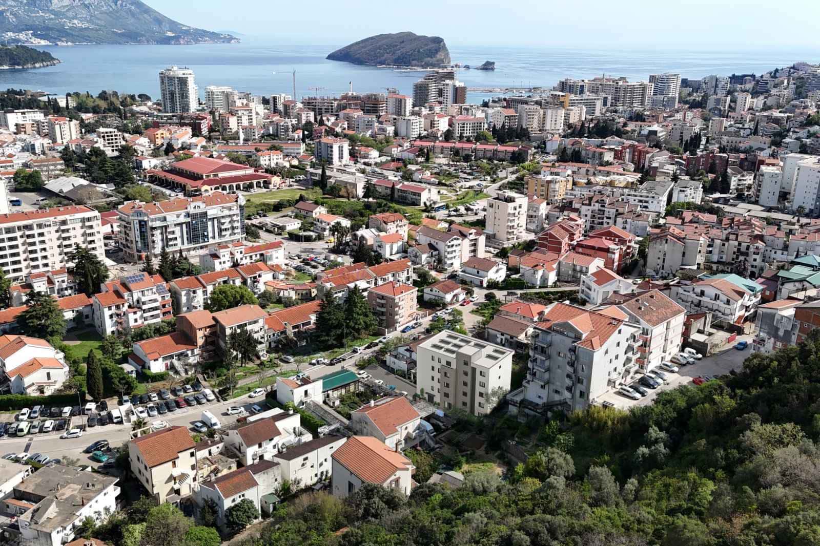 Luftaufnahme einer Küstenstadt mit Gebäuden, Meer und Insel.