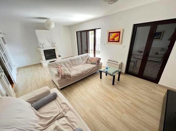 Helles Wohnzimmer mit Kamin und Polstermöbeln in einer Villa in Budva, Montenegro: modernes Interieur mit Panoramafenstern.