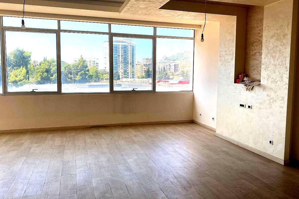 Helles Wohnzimmer mit Panoramafenstern und Blick auf die Stadt in einer Wohnung im Zentrum von Budva, Montenegro. Moderne Ausstattung.