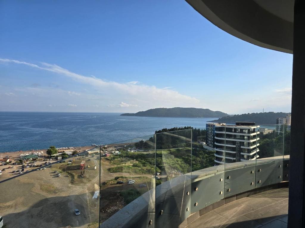 Panoramablick auf das Meer und den Strand von Bečići von einem modernen Balkon mit Glasgeländer, Montenegro.