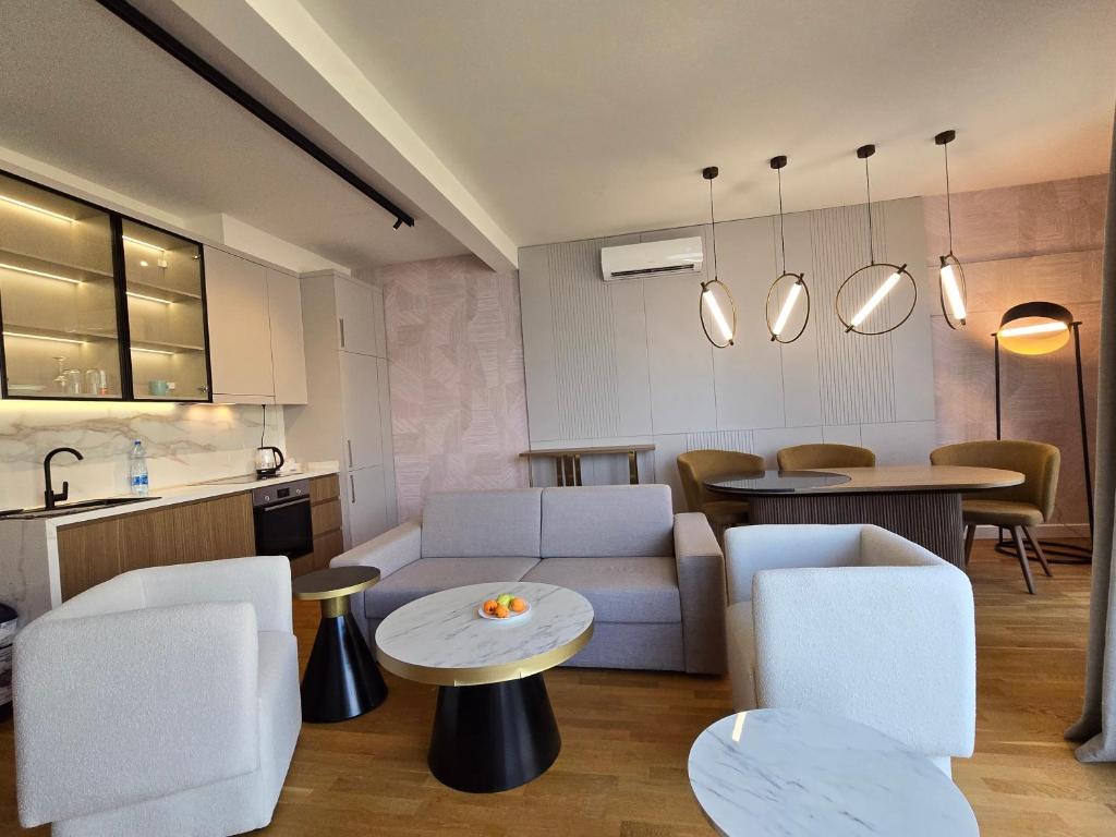 Modernes Wohnzimmer mit Küche in einer Wohnung in Bečići, Montenegro: stilvolle Möbel, Marmortische und gemütliches Interieur.