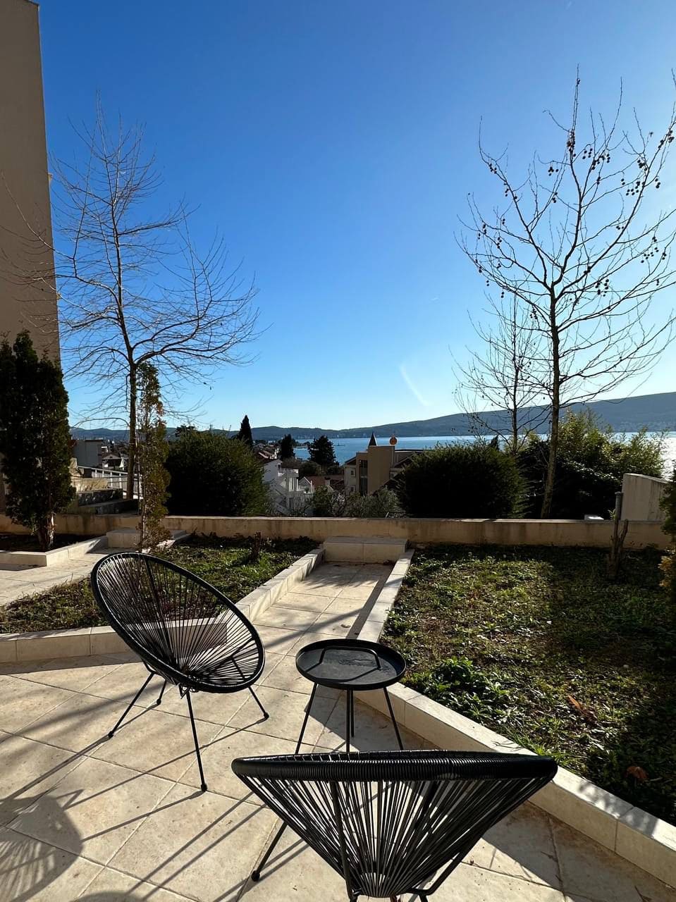 Terasa sa baštenskim nameštajem i panoramskim pogledom na more i planine u stanu, Tivat, Crna Gora.