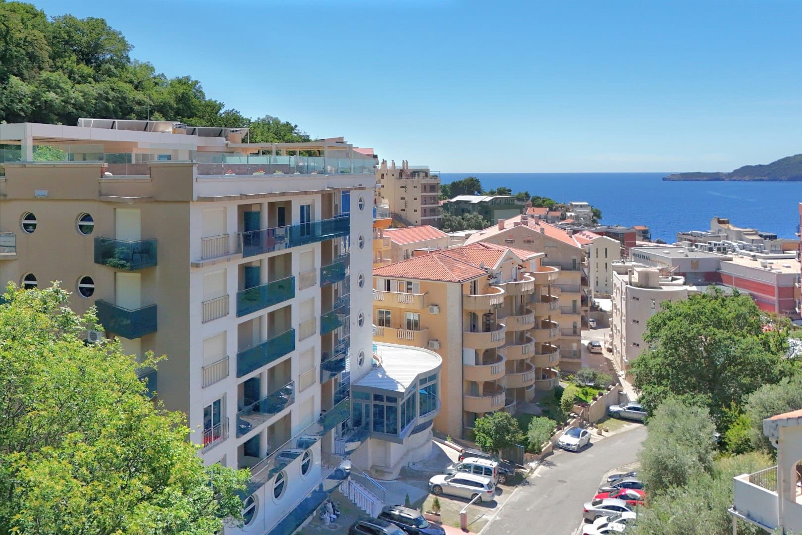 Vue d’une maison moderne à Reževići, Monténégro : vue panoramique sur la mer, le complexe résidentiel et les environs.
