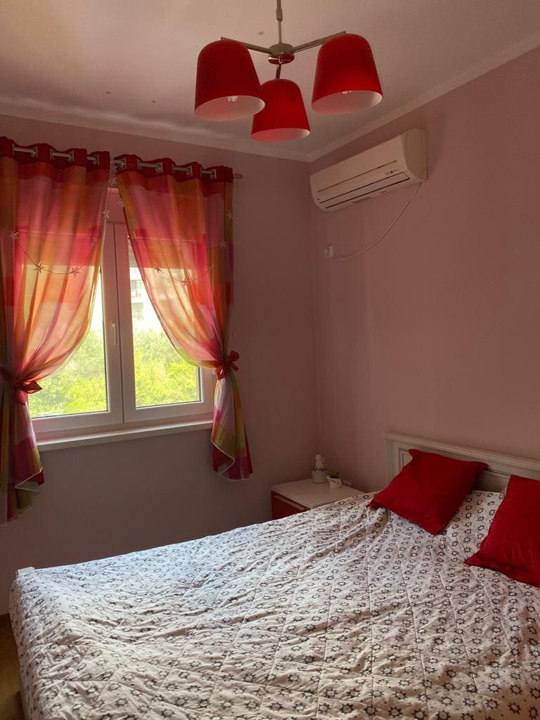 Schlafzimmer mit Doppelbett und Klimaanlage in einer Wohnung zum Verkauf in Bečići, Montenegro.