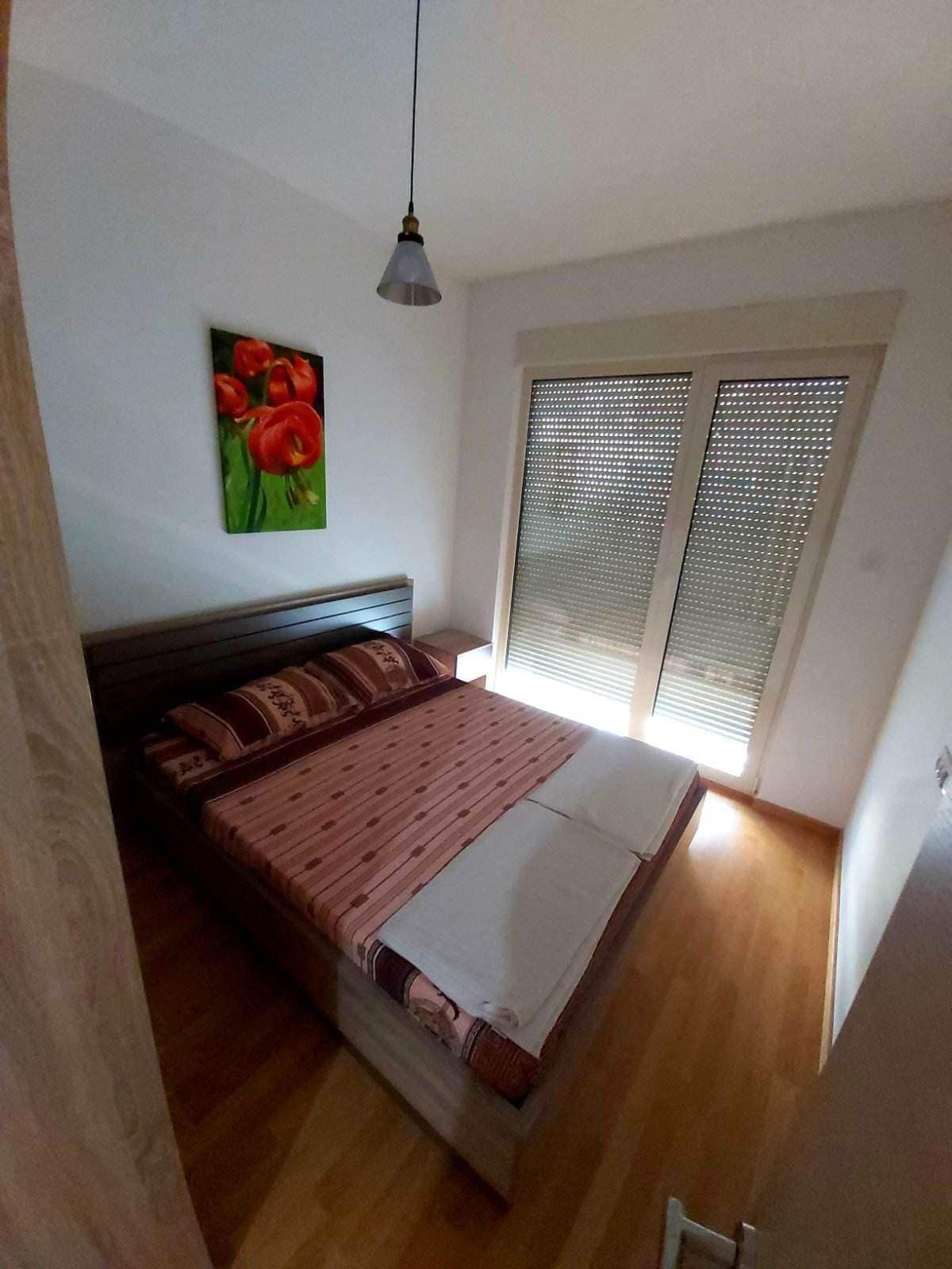 Gemütliches Schlafzimmer mit Doppelbett und hellem Interieur in einer Wohnung in Budva, Montenegro.