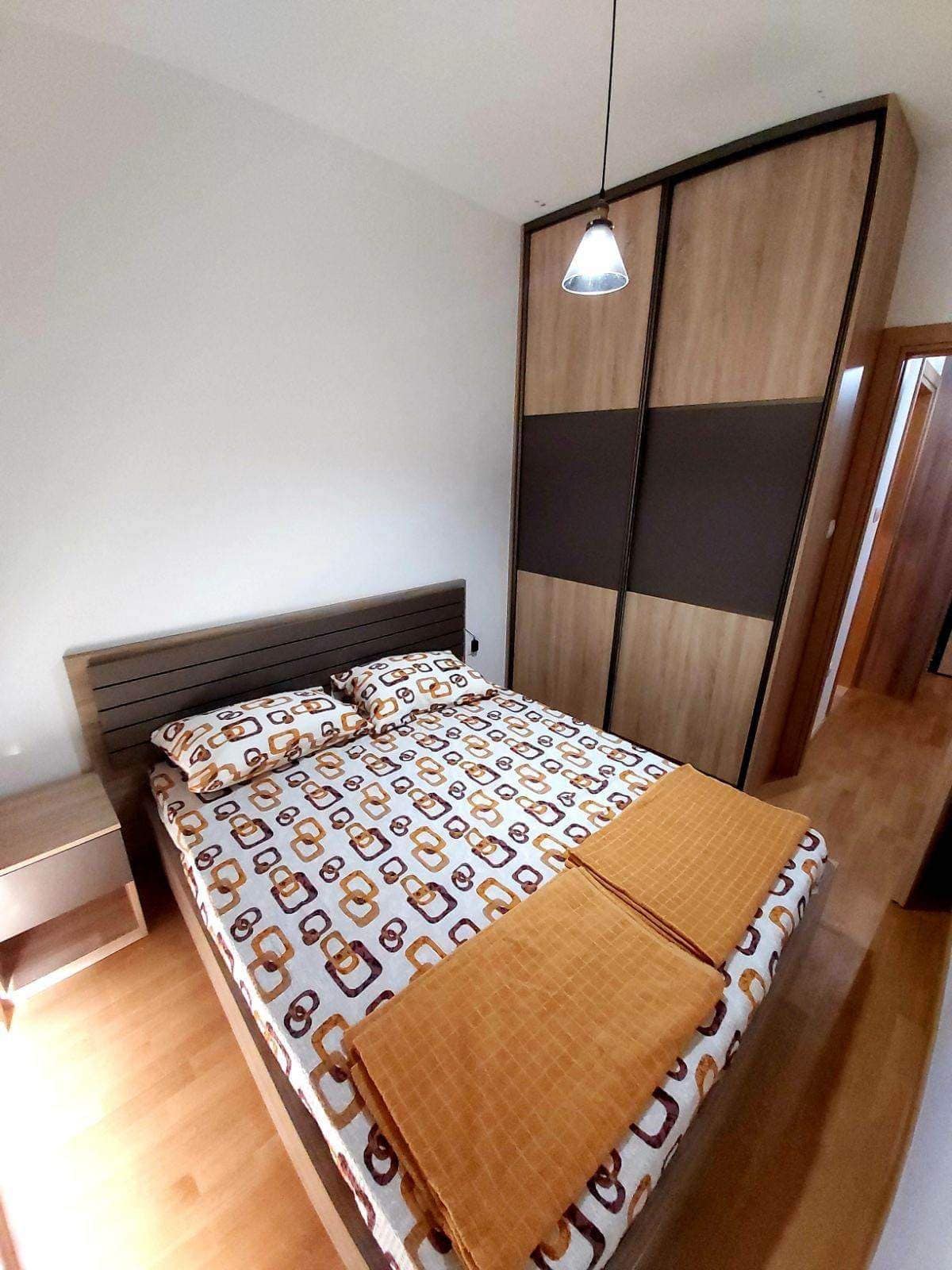 Schlafzimmer in einer Wohnung in Budva, Montenegro: Doppelbett, Einbauschrank und Laminatboden im Interieur.