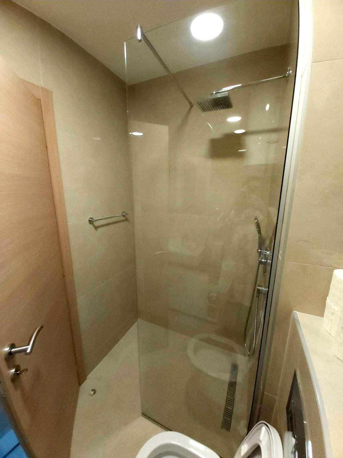 Moderne Duschkabine mit Glasabtrennung im Badezimmer einer Wohnung in Budva, Montenegro.