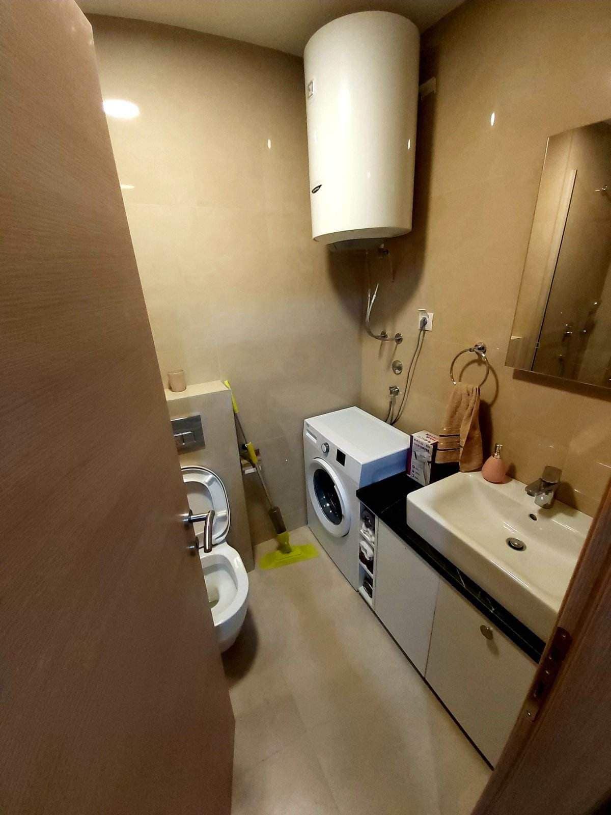 Badezimmer in einer Wohnung in Budva, Montenegro: Bad mit Dusche, Waschmaschine und Boiler im modernen Stil.