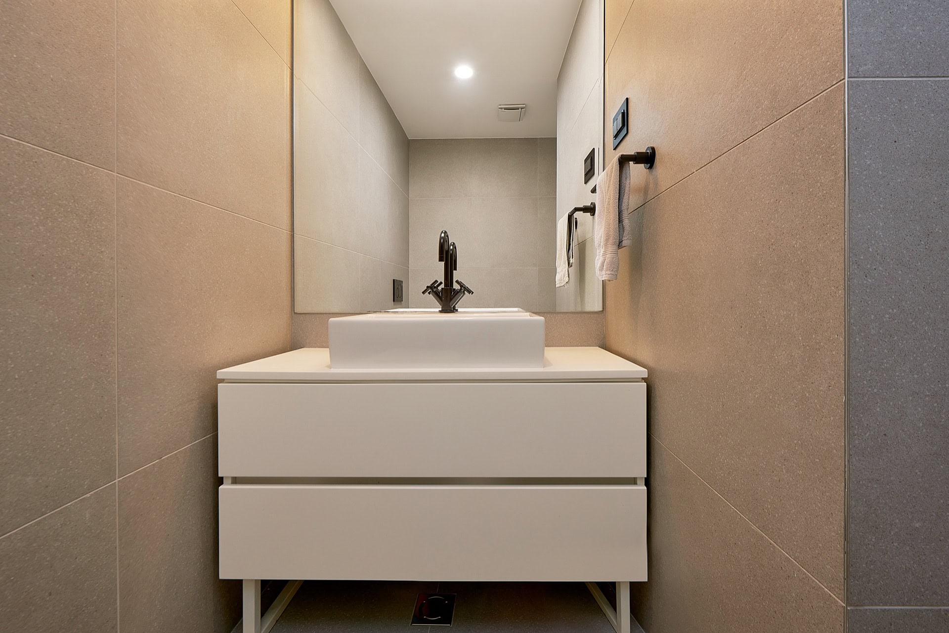 Modernes Badezimmer mit weißem Waschtisch und Aufsatzwaschbecken in einer Wohnung im Zentrum von Budva, Montenegro.